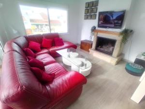 a living room with a red leather couch and a fireplace at terraza al mar in Pineda de Mar