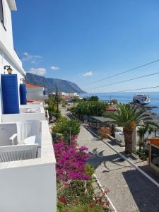 a balcony of a house with pink flowers and the ocean at Agia Roumeli Hotel in Agia Roumeli