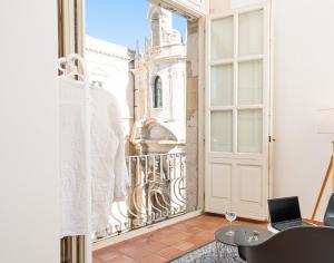 a room with a window and a laptop on a table at Maestranza72 by Bed&Bros in Siracusa