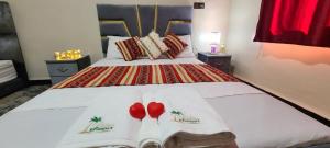 ein Schlafzimmer mit einem Bett mit zwei roten Kissen in der Unterkunft Traditional place with a Special Moroccan touch I Fibre Internet Up to 100 Mbps I PALMS Residence in Er Rachidia