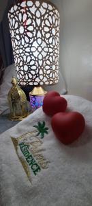 zwei Herzen auf einem Handtuch mit einem Weihnachtsschild auf einem Bett in der Unterkunft Traditional place with a Special Moroccan touch I Fibre Internet Up to 100 Mbps I PALMS Residence in Er Rachidia