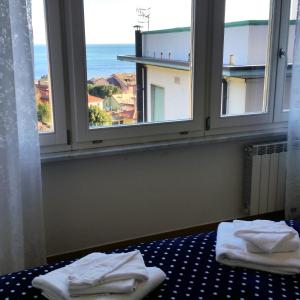 a room with two windows with towels on a bed at Ca Messina in Monterosso al Mare