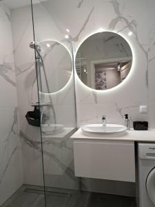 ein Bad mit einem Waschbecken und einem Spiegel in der Unterkunft Apartament Waldi in Kołobrzeg