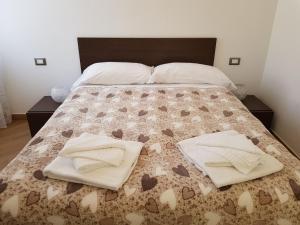 een bed met twee witte handdoeken erop bij Ca Messina in Monterosso al Mare