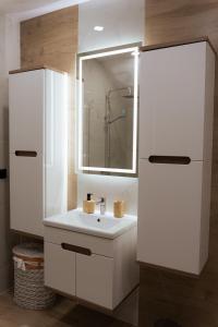 奧古斯圖的住宿－Dom przy molo，白色的浴室设有水槽和镜子