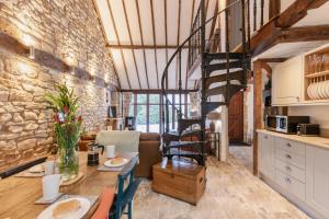a kitchen and living room with a stone wall at Otters Abode in Blockley
