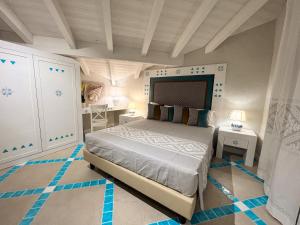 a bedroom with a large bed and a desk at Suite Villa Aquamarina con Jacuzzi Riservata in Porto Pino