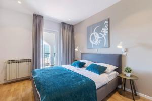 a bedroom with a large bed with a blue blanket at Apartment Zulijani A6 in Rabac