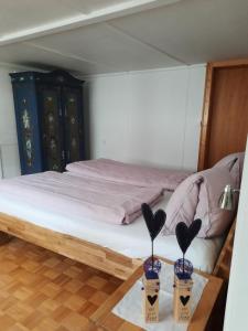 1 dormitorio con 1 cama y 2 jarrones sobre una mesa en Vreni`s Ferienwohnung, en Gais