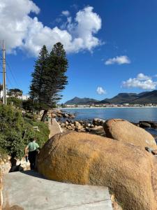 a man walking on a path next to the water at On the Sea in Cape Town