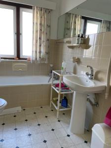ein Badezimmer mit einem Waschbecken und einer Badewanne in der Unterkunft On the Sea in Kapstadt