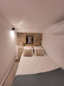 a bedroom with a large white bed with two pillows at Emiliadourohouse in Marco de Canavezes