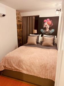 a bedroom with a bed with a painting of a woman at Emiliadourohouse in Marco de Canaveses