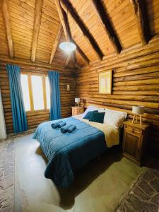 1 dormitorio con 1 cama en una cabaña de madera en cabaña 17 Potrerillos en Mendoza