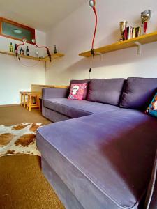a living room with a purple couch and a table at Sestriere Borgata appartamento in montagna Casa di Bertu in Borgata Sestriere