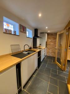 a kitchen with a sink and a counter top at New Bury Cottage near Goodwood in Chichester