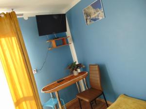 Pokój z biurkiem i telewizorem na niebieskiej ścianie w obiekcie POD RÓŻĄ w mieście Kasina Wielka