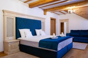 Conacul Baciu في فوندو مولدوفي: غرفة نوم مع سرير كبير مع اللوح الأمامي الأزرق