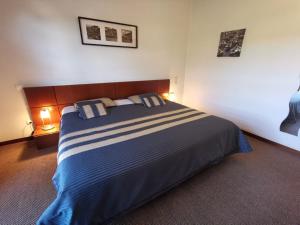 a bedroom with a large bed with two pillows at Hotel La Fontaine in Esmoriz