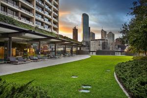 a building with chairs and a green lawn in front of a city at Luxury designer suite in most prestigious location in Melbourne in Melbourne