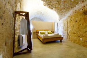 Schlafzimmer mit einem Bett und einem Spiegel in der Unterkunft Casa Vacanza La Cava nel Barisano Suite Matera in Matera