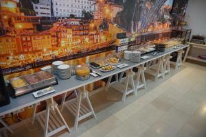 una mesa larga con platos de comida. en Hotel La Fontaine, en Esmoriz