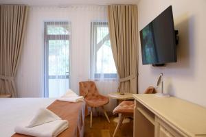 Conacul Baciu في فوندو مولدوفي: غرفة فندقية بسرير وتلفزيون بشاشة مسطحة