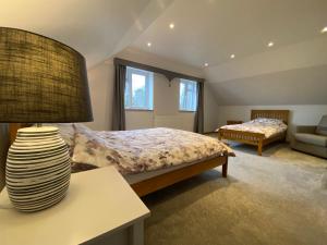 a bedroom with a bed and a lamp on a table at New Bury Cottage near Goodwood in Chichester