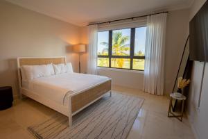 a bedroom with a bed and a large window at The Country Club Residences at Grand Reserve in Rio Grande