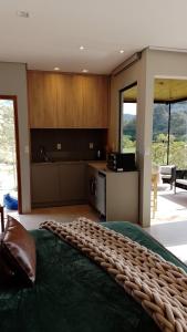 1 dormitorio con 1 cama verde grande y cocina en La Contemporânea Cabanas prox a cidade vista para ponto turístico, en Urubici