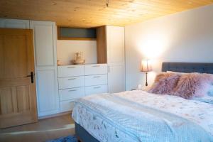 ein Schlafzimmer mit einem Bett mit einer Kommode und einem Schrank in der Unterkunft Traumwohnung auf kleiner Pferdefarm in Thun