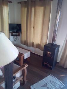 a living room with a fireplace and a stove at La Quijotada in Punta Colorada