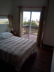 a bedroom with a bed and a door to a balcony at La Quijotada in Punta Colorada