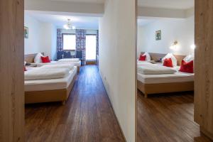 uma fila de camas num quarto com pisos em madeira em Ferienhotel Fuchs em Söll