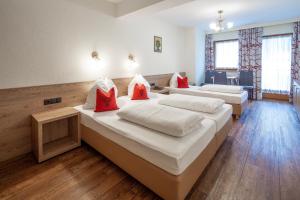 a room with two beds with red pillows at Ferienhotel Fuchs in Söll