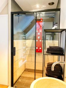 a glass shower in a room with towels at B&B de Muldermolen in Schinnen