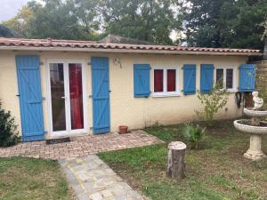 uma pequena casa com portas azuis e uma fonte em HOUDARLING Chalet avec Hammam Sauna Jacuzzi Privatif em Nîmes
