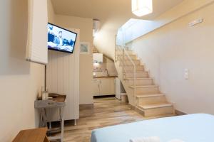 a room with a staircase with a tv on the wall at Aelia Home Suites in Marathopoli