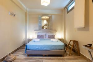 a bedroom with a bed with a blue comforter and a mirror at Aelia Home Suites in Marathopoli