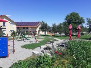 um parque infantil com um baloiço num quintal em Ferienwohnung 10 em Ochsenhausen