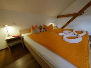 um quarto com uma grande cama laranja com animais de peluche em Ferienwohnung 7 em Ochsenhausen