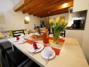 a kitchen with a table with yellow tulips on it at Ferienwohnung 5 in Ochsenhausen