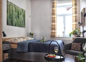 a bedroom with a bed and a table with a glass of wine at Apartmány U Aloise in Dolní Morava