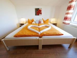a bed with two heart shaped towels on it at Ferienwohnung 4 in Ochsenhausen