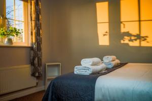 a bedroom with a bed with towels on it at The Old Dairy in Boston