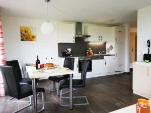 a kitchen with white cabinets and a table and chairs at Ferienwohnung 2 in Ochsenhausen