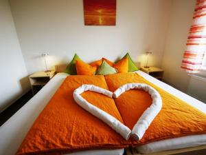 Una cama con una almohada en forma de corazón. en Ferienwohnung 2, en Ochsenhausen