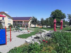 un parque infantil con columpio en un patio en Ferienwohnung 11 en Ochsenhausen