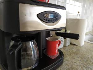 a coffee maker on a counter with a red cup at Sofia sea view house in Faros