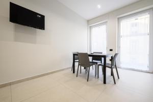 a dining room with a table and chairs and a flat screen tv at Via Niccolò Tommaseo 4 - appartamento 2 in Naples